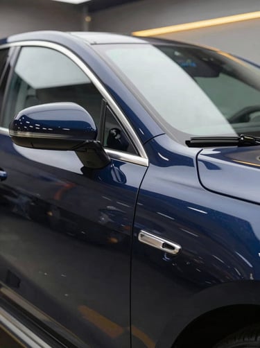 Close-up of a high-end luxury car door with a sharp light reflection showing a perfect, smooth surface after PDR repair. Professional workshop lighting, navy and gold accents in the background.