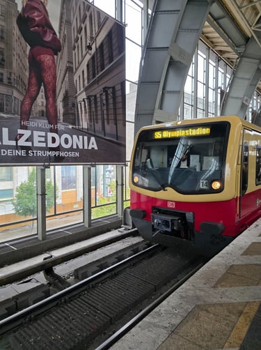 a train is parked in front of a large poster
