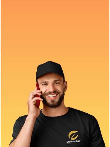 Homme souriant, portant un t-shirt avec un logo imprimé, parlant sur un smartphone.