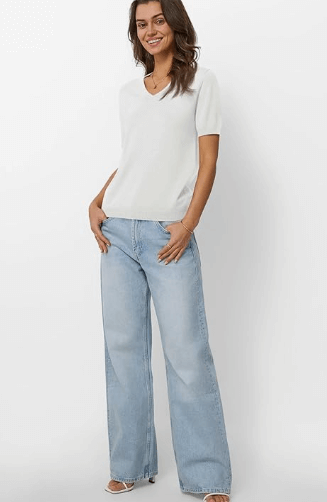 a woman in a white shirt and jeans jeans