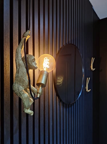 Un luminaire singe sur des panneaux en latte de bois