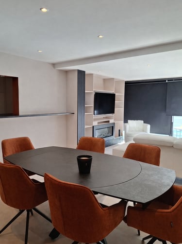 Table de salle à manger avec chaises terracotta dans un séjour beige et noir