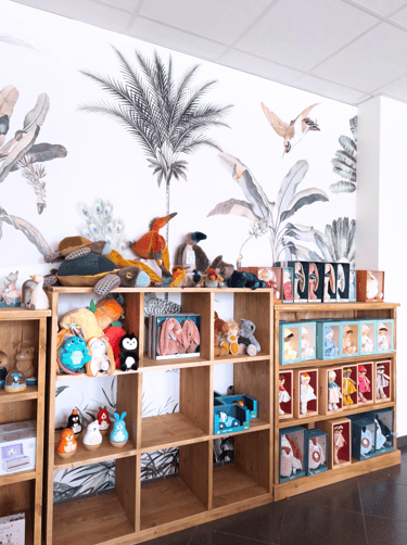 Magasin de jouets avec des mobiliers en bois du papier peint fleuri et des peluches