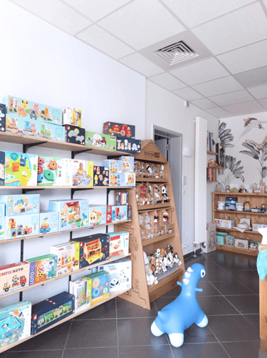 Magasin de jouets avec des étagères en bois et du papier peint fleuri