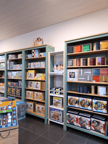 Transformation d'un magasin de jouets avec vue sur des étagères vert sauge