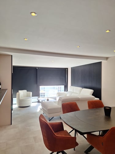 Image d'un séjour avec table de salle à manger chaises terracotta canapé blanc et éléments noirs