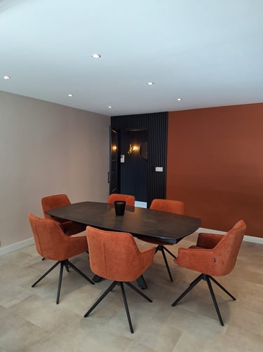 Table de salle à manger avec chaises terracotta mur terracotta et lattes de bois noir avec verrière