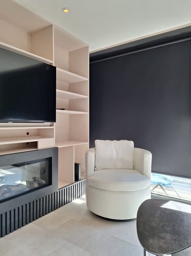 Zoom sur un mobilier sur-mesure beige avec des lattes de bois noires et un fauteuil blanc