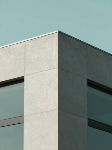 A minimalist architectural detail of a building corner against a clear sky. The composition is sharp and geometric, featuring textures of smooth concrete and glass. Incorporates #A7C5C3 and #1C2826 in the shadows and highlights. Professional, calm, and high-resolution photography.