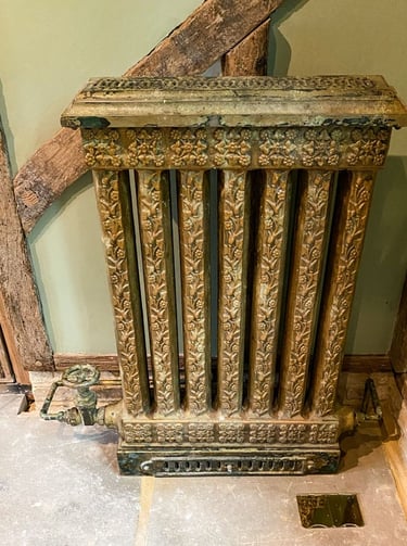 Vintage radiator with layers of paint applications and a faux painted pipe to match.
