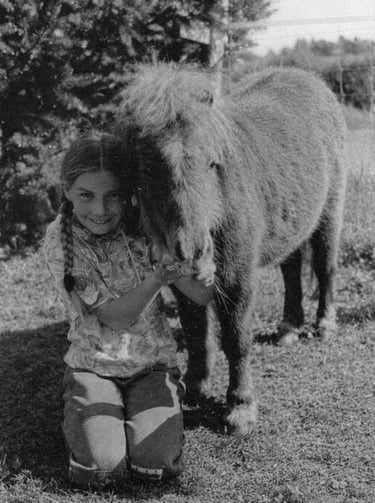 Kindheitsbild der Ponytante wie sie ein Ponyfohlen kuschelt