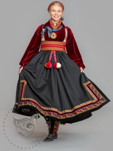 A woman in a bunad with a velvet shirt and wide belt