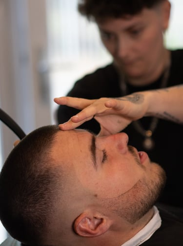 La barbière qui réalise une coupe à la lame dans les cheveux d'un homme