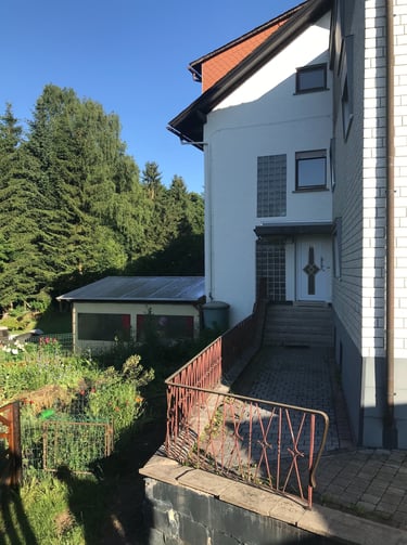 Separater Eingangsbereich des Neubaus mit angrenzendem Wintergarten links