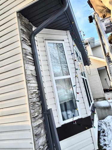 Everdrains team removing hail damaged gutter system in Calgary.