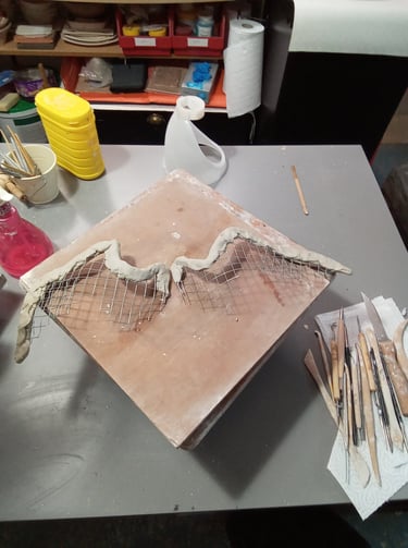 Structure en grillage des ailes de la sculpture Iris partiellement recouvertes d'argile