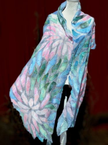 Handmade nuno felted scarf with pastel floral patterns in pink, blue, and green on a white silk base.