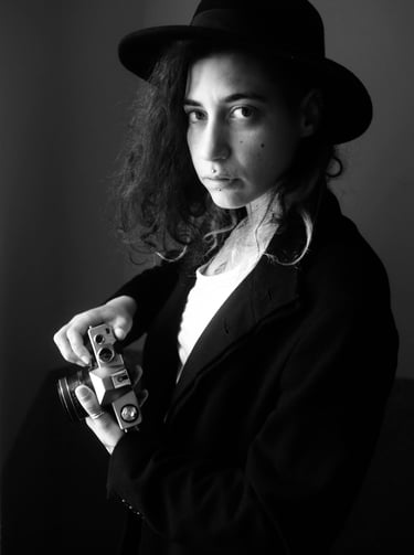 a woman photographe with a hat posing for a photo