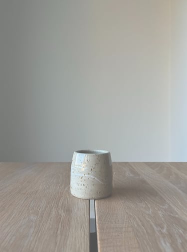 Kleiner, heller Keramikbecher im Japandi-Stil