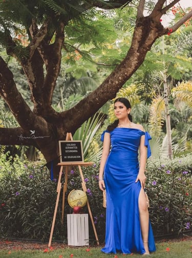 una adolescente con vestido azul celebrando la graduación de su preparatoria