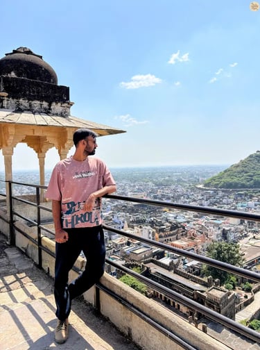 Traveler overlooking the blue city of Bundi from Garh Palace, capturing the panoramic view below.