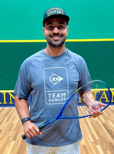 a man in a blue shirt and white shorts holding a tennis racket