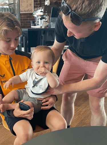 a man and two children sitting in a chair