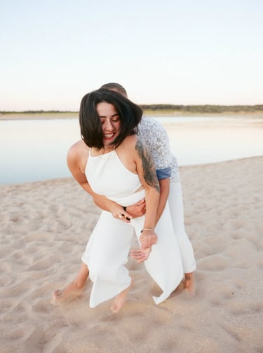 un couple s'amuse et joue lors d'un shooting couple sur des tons pastel plage du Veillon en Vendée