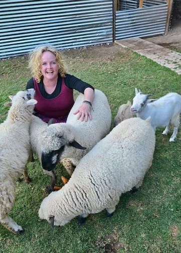 Sunni Dawson smiling with sheep and goats during animal communication session