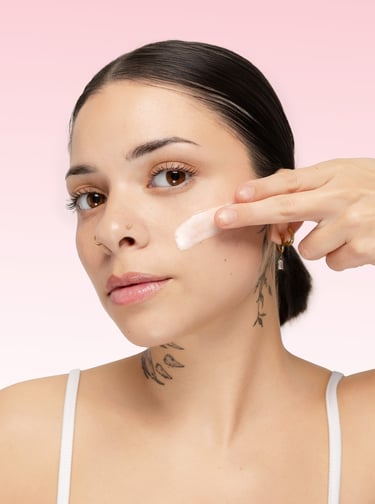a model applies a skincare product in her face