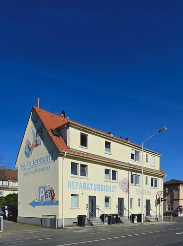 Ein Gelbes Haus mit dem logo von Hausgeräteservice jentsch