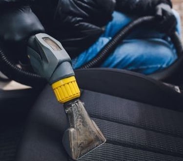 Nettoyage intérieur auto à Verviers: détachage d’un siège grâce à une shampouineuse professionnelle.