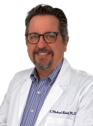 man in a white lab coat wearing glasses