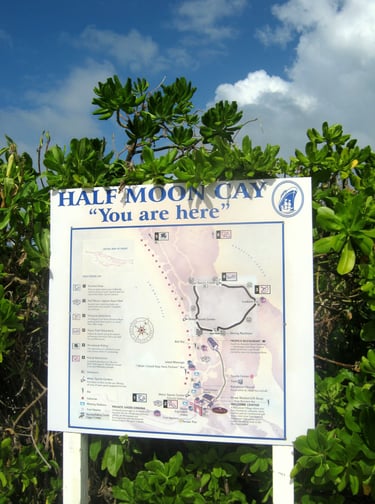 The roaming purser explorando a ilha de half moon cay placa de direções na ilha