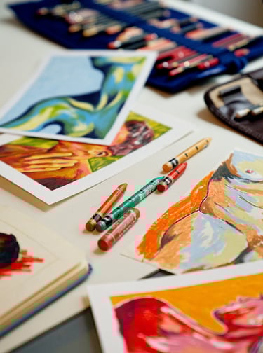 a table with a bunch of art work on it