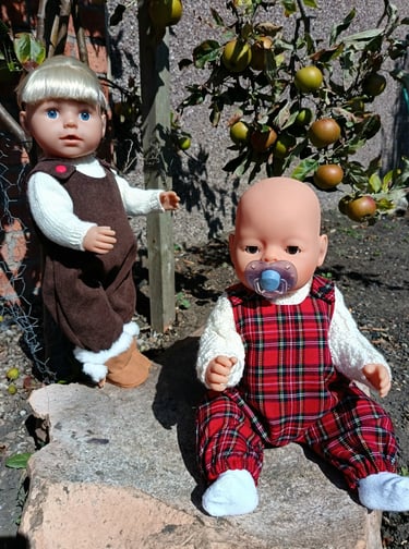 Zapf Baby Born and Big sister dolls dressed for autumn next to apple trees