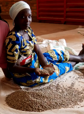 a woman sitting on a bed with a pile of coffeeseeds
