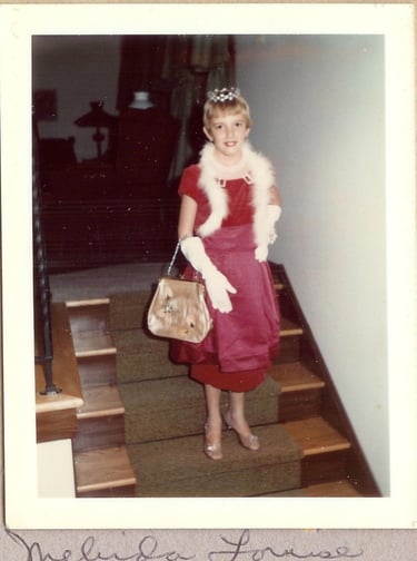 Vintage polaroid of a young girl in a red dress, tiara, and white boa for dress up.