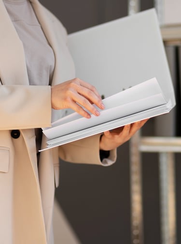 a woman in a business suit is holding a laptop