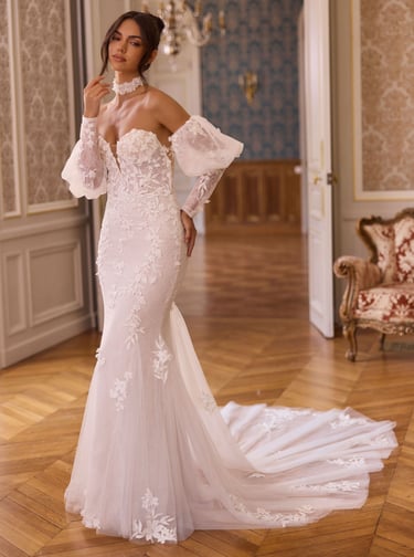 Elegant bride wearing an off-the-shoulder mermaid wedding dress with floral lace and puff sleeves.