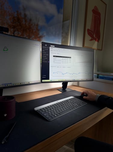 a person sitting at a desk with a computer monitor and keyboard