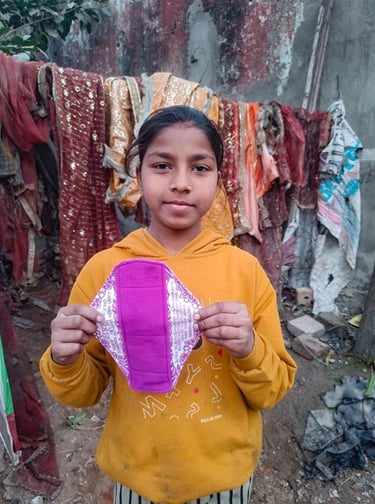 Young girl holding up a Hanaru reusable sanitary napkin