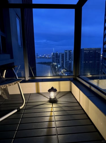 Small balcony garden with compact furniture, green plants, and warm decor for comfortable outdoor li