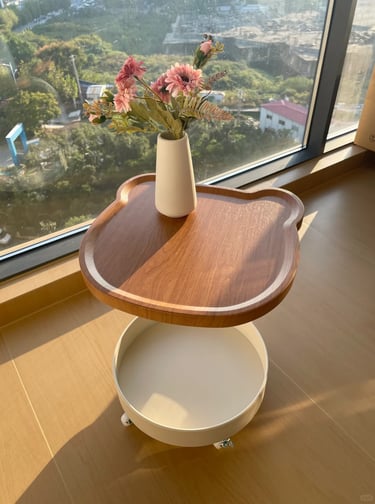Wooden small side table by a window with flowers, ideal for a cozy balcony reading corner or outdoor