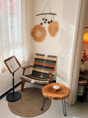 Comfortable balcony reading nook with soft cushions, greenery, and a small table for coffee and book