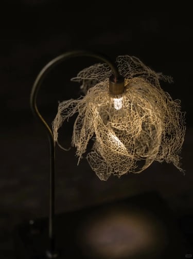 Close-up of a warm leaf-shaped decorative lamp creating soft light for a quiet reading corner.