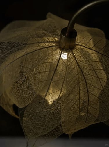 Close-up of a warm leaf-shaped decorative lamp creating soft light for a quiet reading corner.