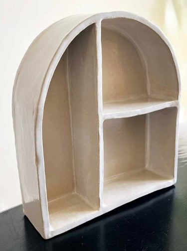 a small white ceramic shelf with shelves