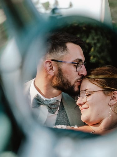 Mariés qui s'embrassent dans le reflet du rétroviseur