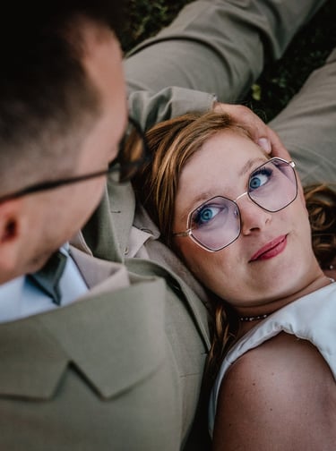 Une mariée en robe blanche est allongée sur les genoux de son époux